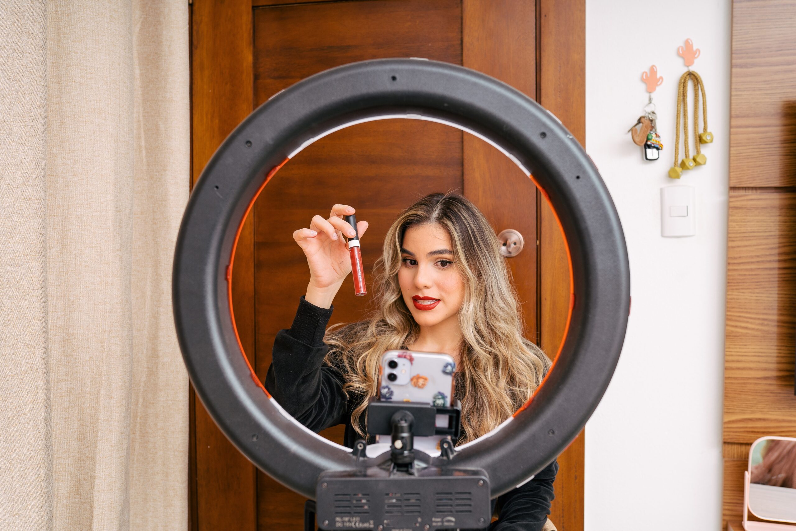 Influencer holding make-up in front of ring light