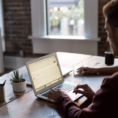 Man sitting at a table working on laptop