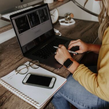 Person sitting at a table at home and working from laptop