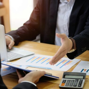 man with spreadsheets doing a handshake