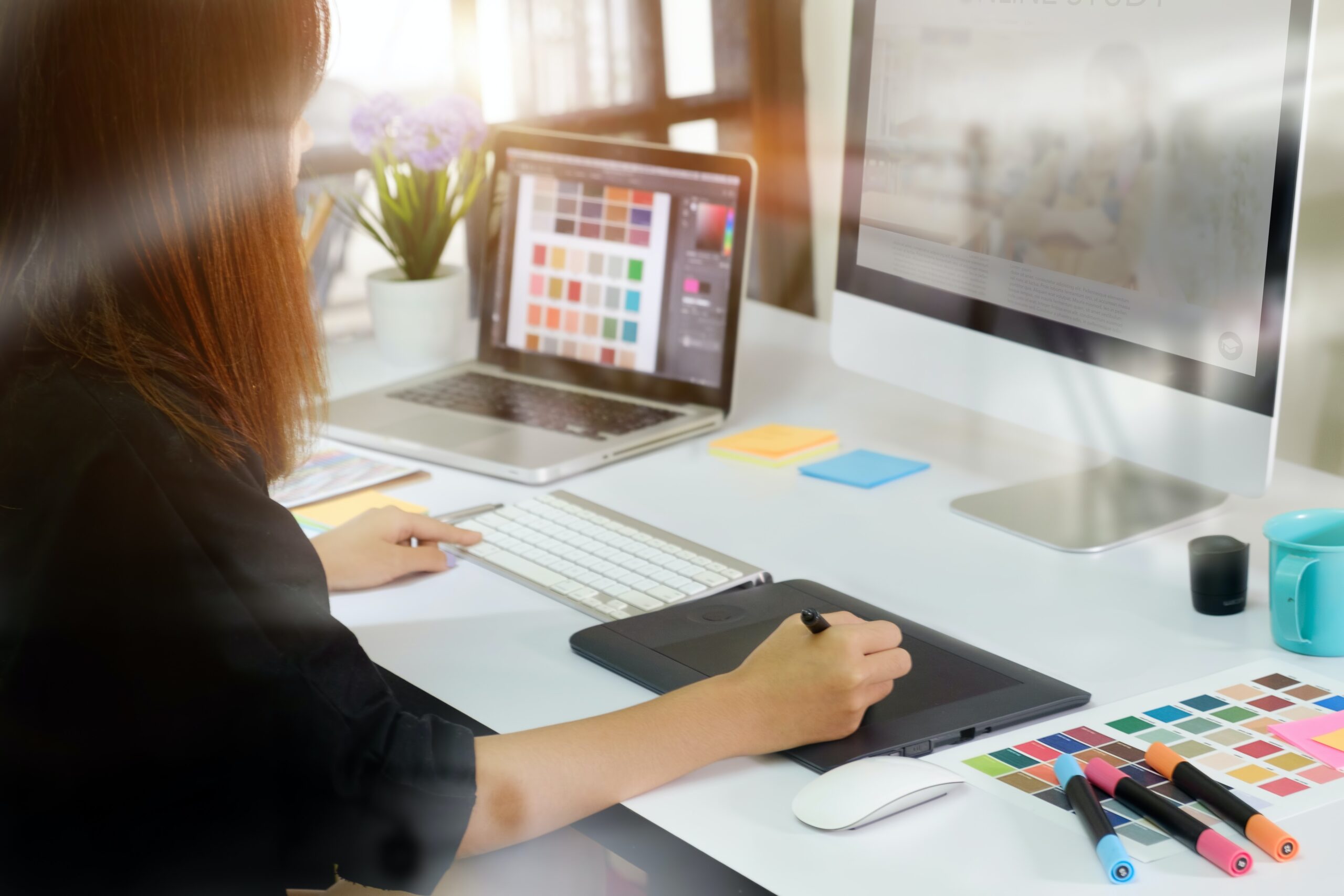 Female graphic designer working on computer and ipad