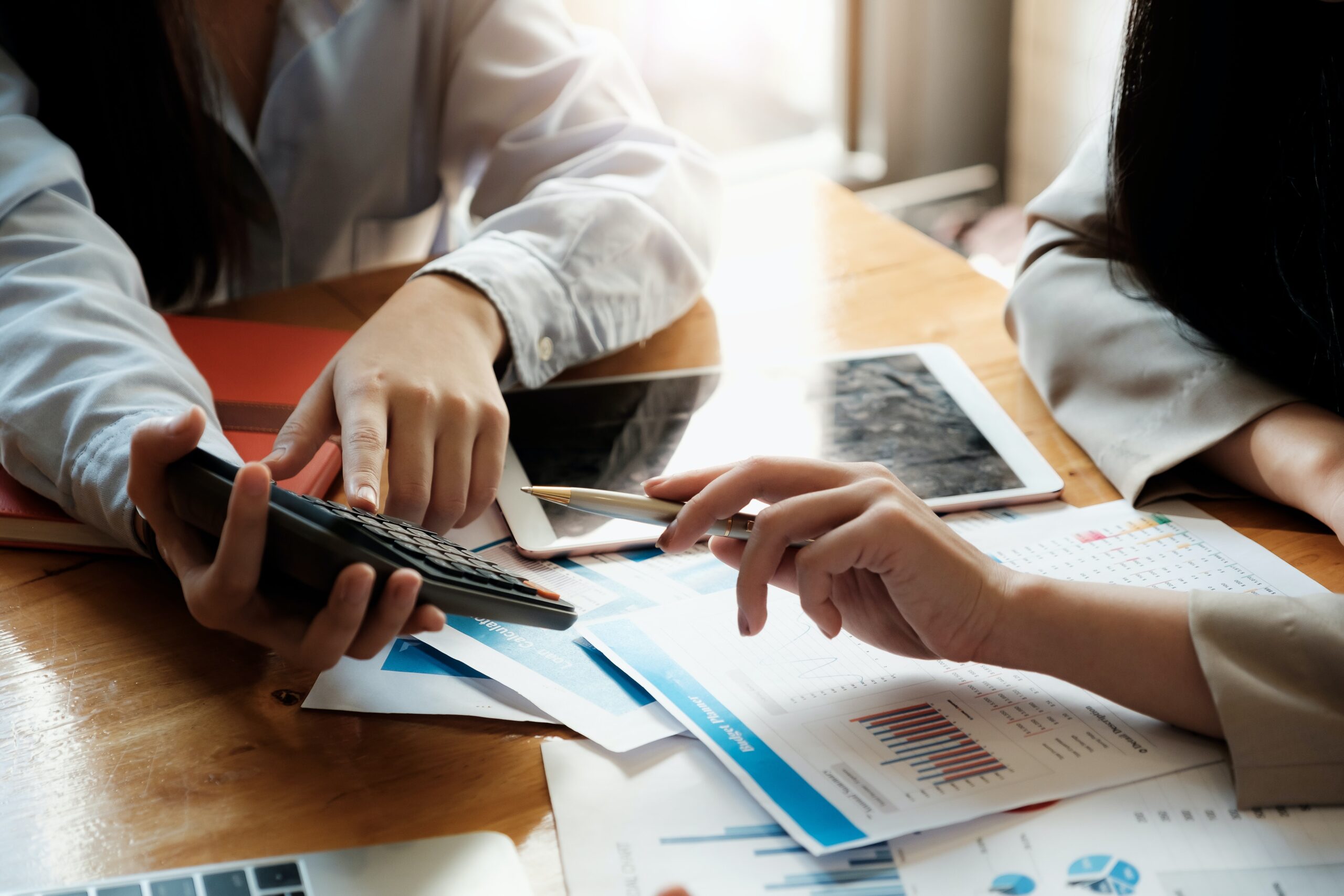 Two people at table reviewing papers and calculators