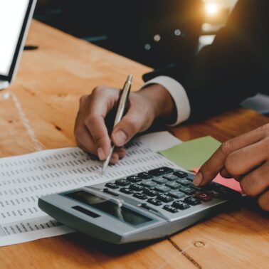 Close up business man with calculator and spreadsheet