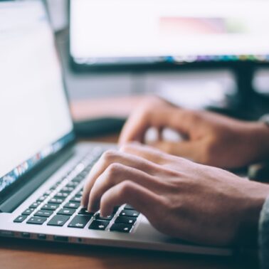 Person typing on Apple laptop
