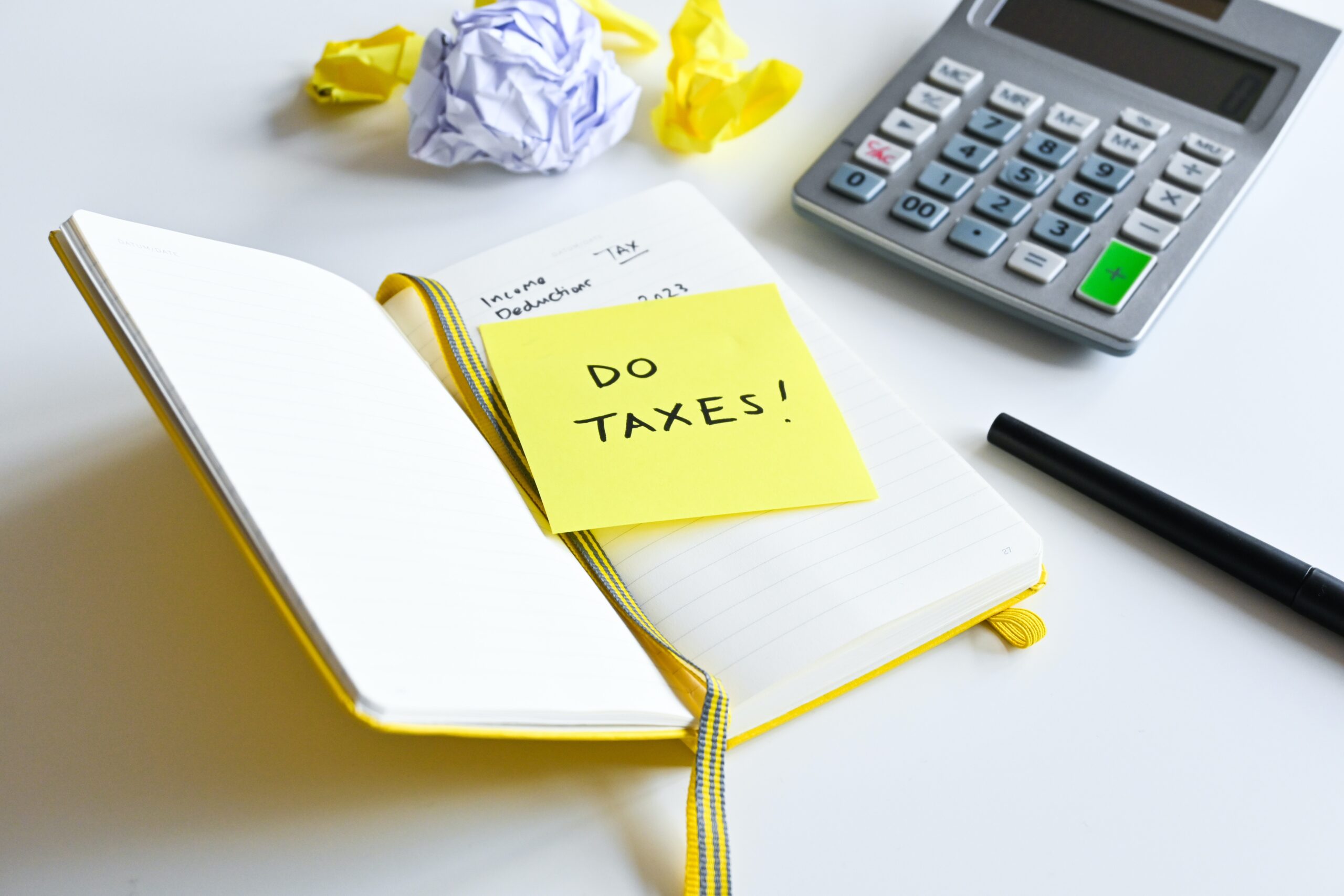 Notebook on table with a sticker that says do taxes