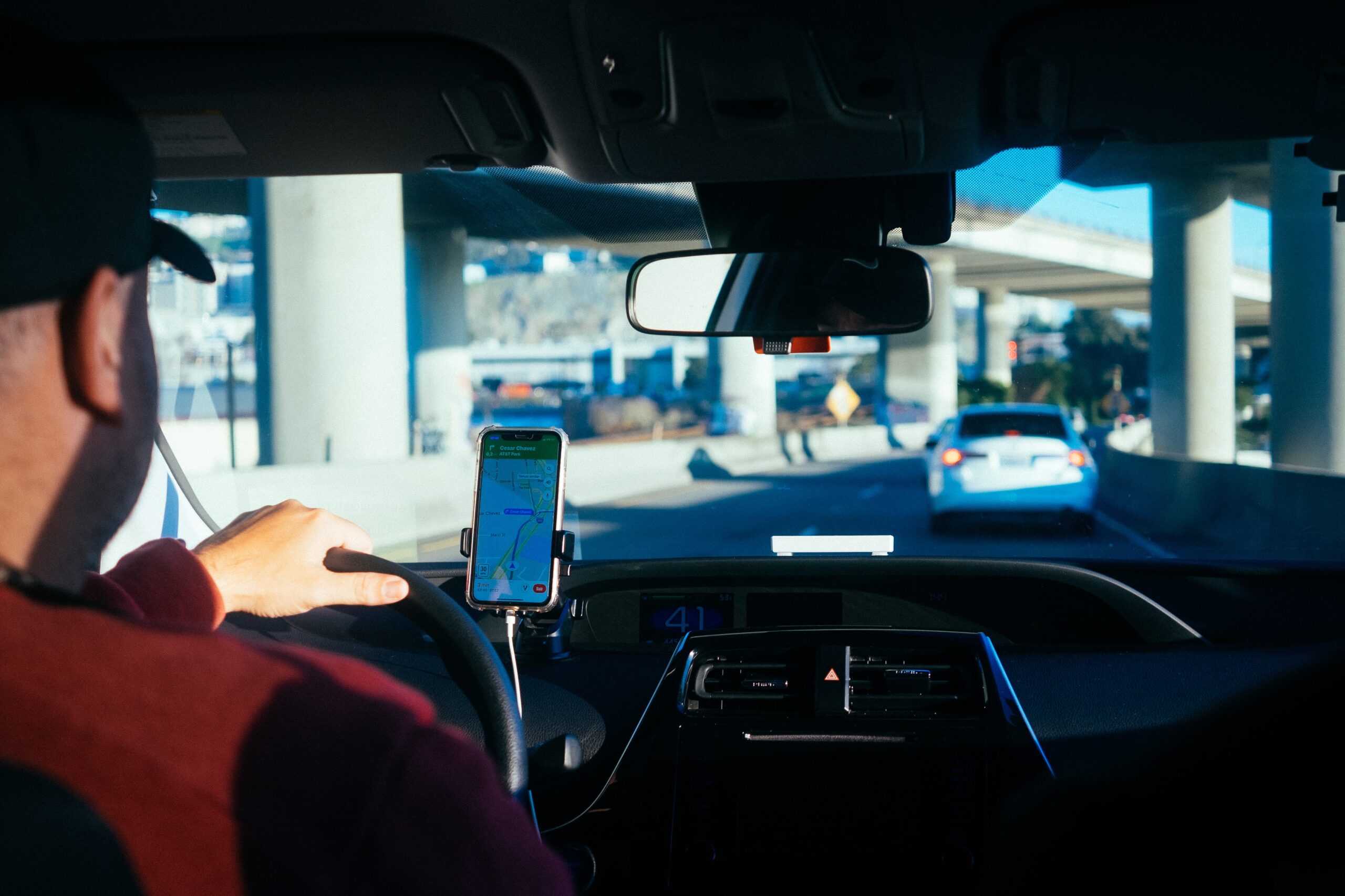person driving car with a phone on their dash