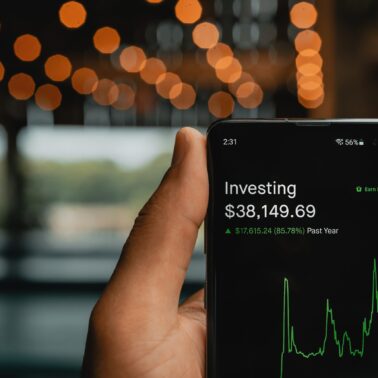 Person holding black smartphone showing investment app