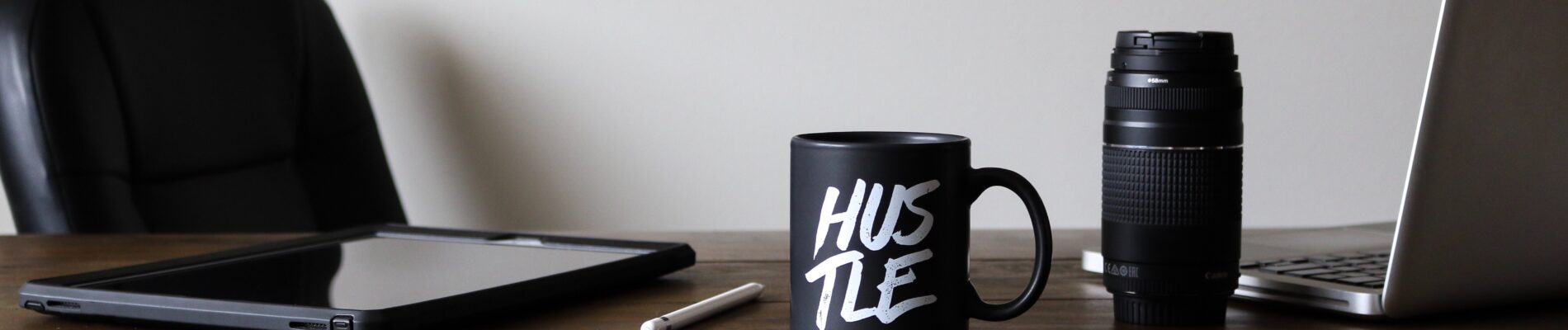 Black coffee mug sitting on a wood desk
