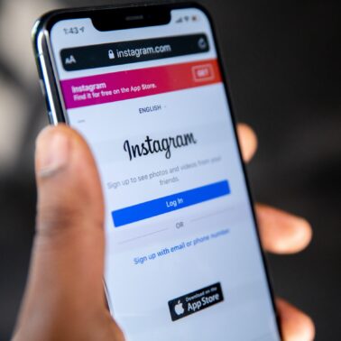 Person holding phone with Instagram on home screen