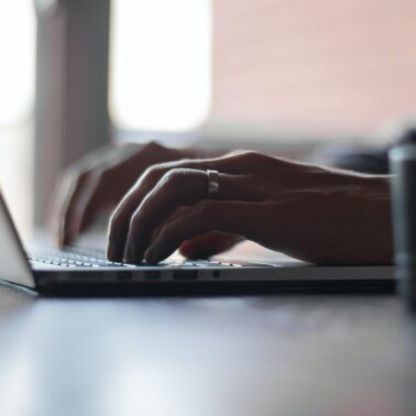 hands typing on macbook